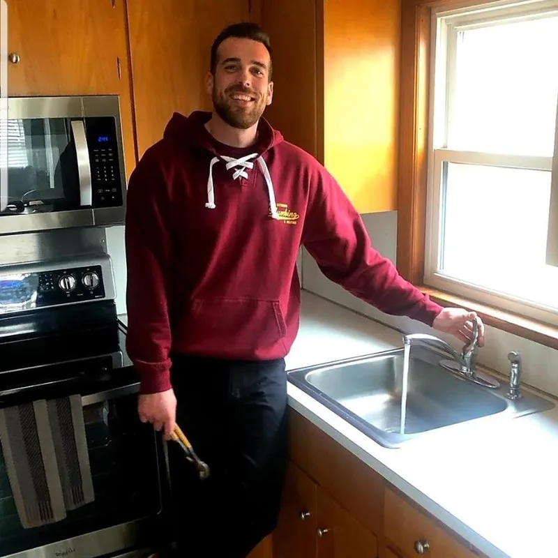 James Hickox, owner of South Weymouth Plumbing & Heating, working on a kitchen sink